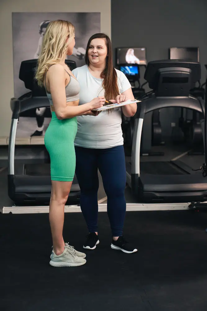 Personal trainer coaching client in Richmond gym, discussing fitness plan and goals.